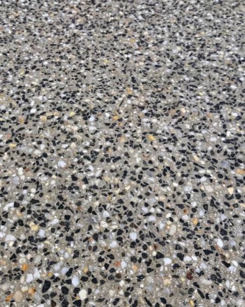A close view of grey, white and black exposed aggregate stone in a finished surface
