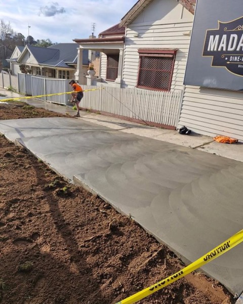 A new concrete path and apron in front of a weatherboard house