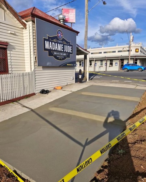 New concrete laid across the frontage of a weatherboard shopfront