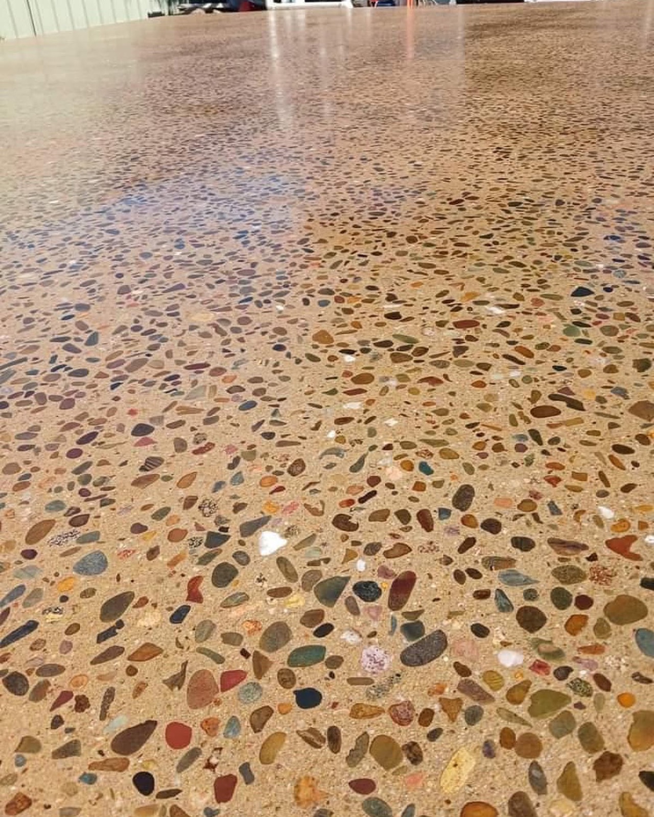 A polished honey-toned aggregate surface with the stone washed back and sealed