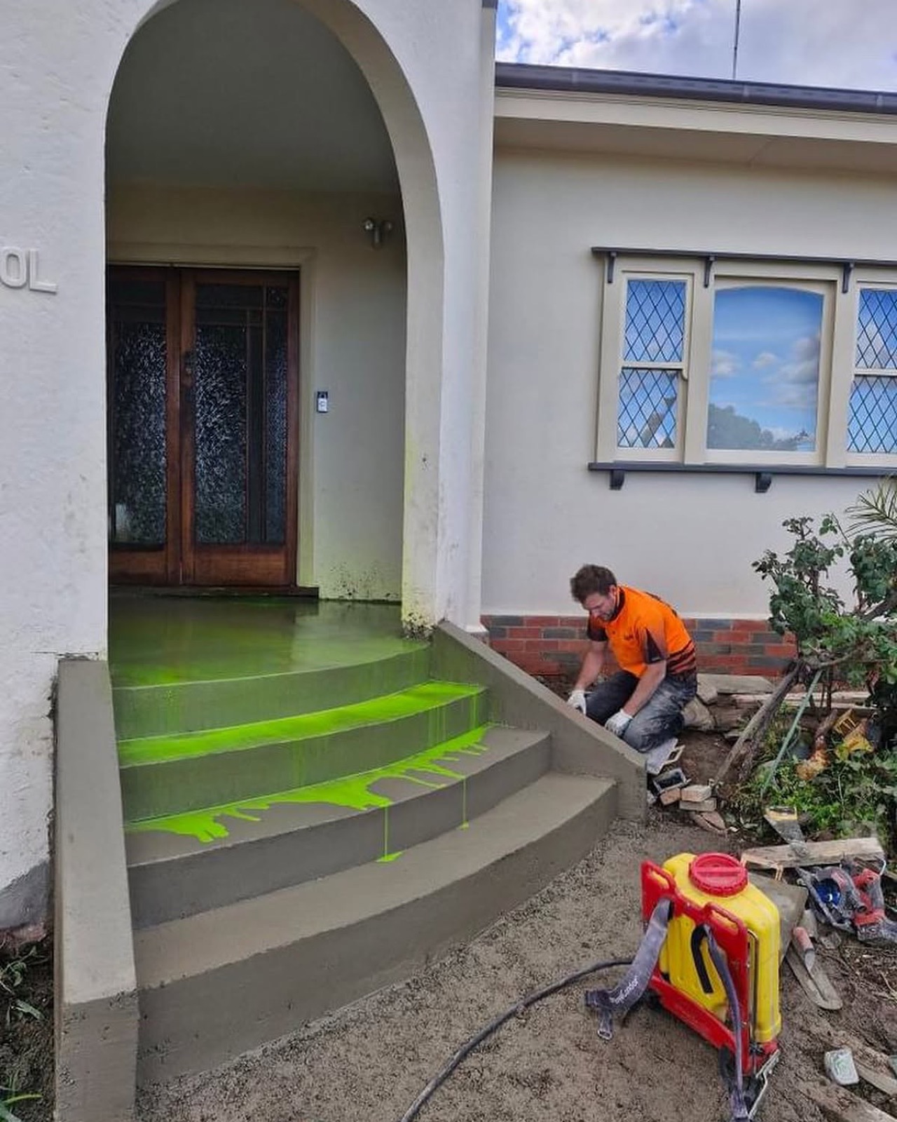 A concreter finishing rendered front steps at a period house